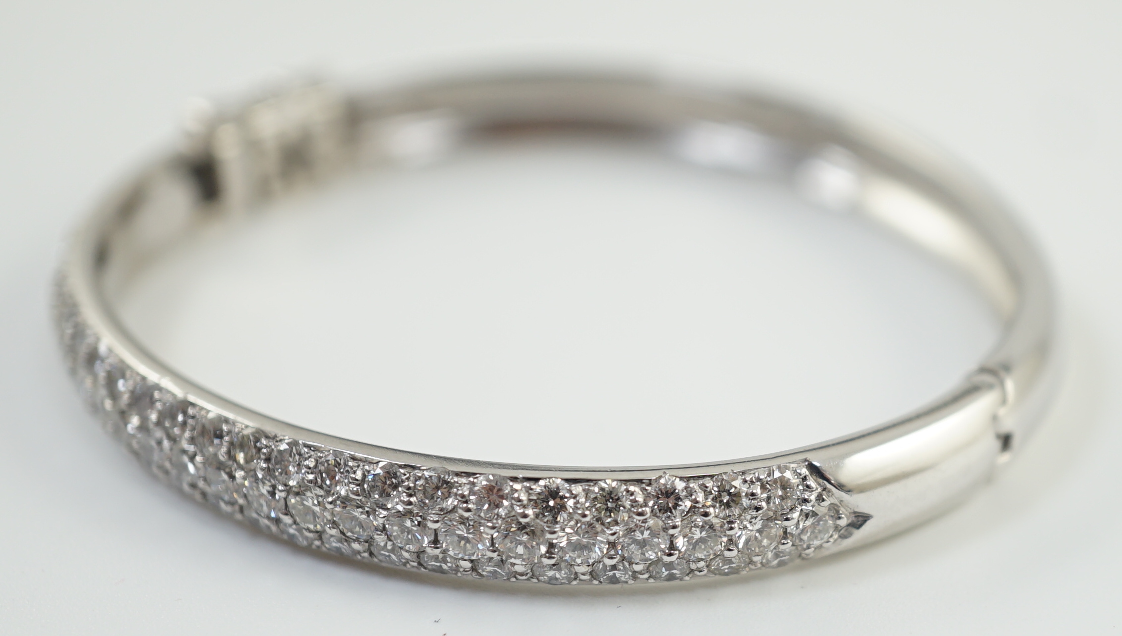 A modern 18ct white gold and pave set diamond hinged bangle